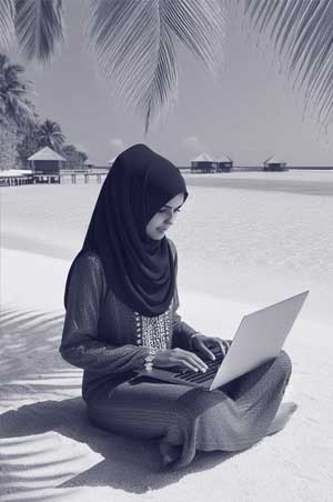 Maldivian girl holding a laptop in a beach.